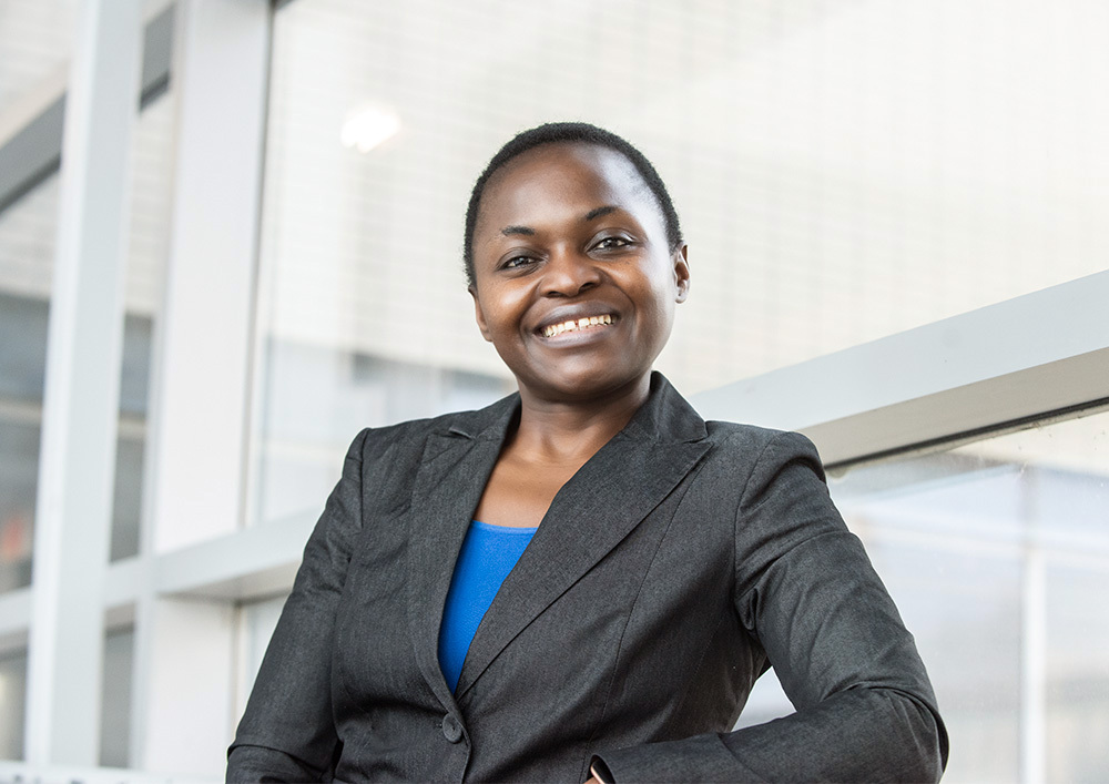 Rivellie Tchuisseu, une femme noire aux cheveux courts, sourit fièrement.