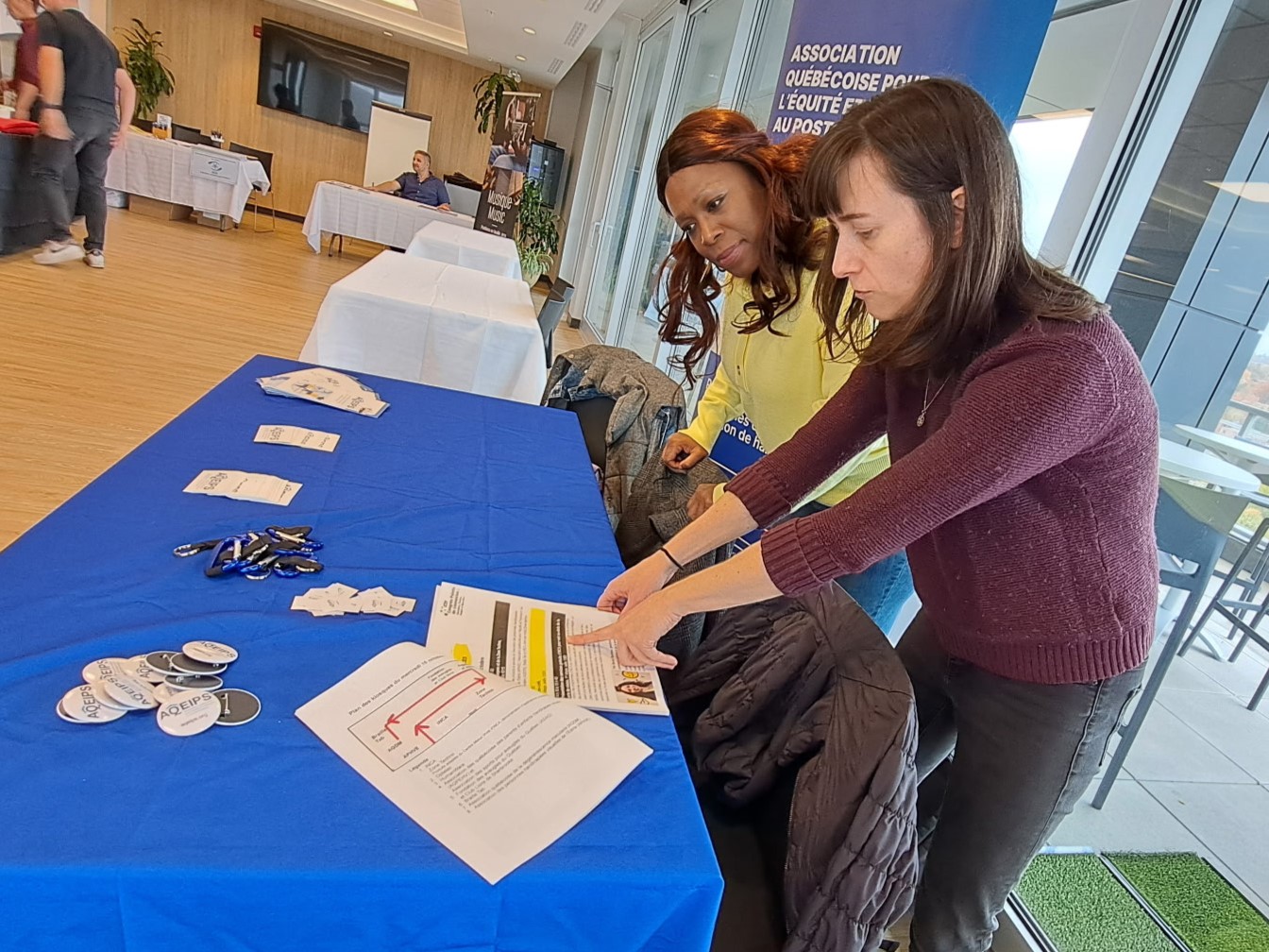 Felicity Spence, chargée de projet à l'AQEIPS, et Sergeline Isidore, ancienne administratrice de l'AQEIPS et fondatrice de Mon Bras Droit Éduc, tiennent un kiosque lors de l'événement.